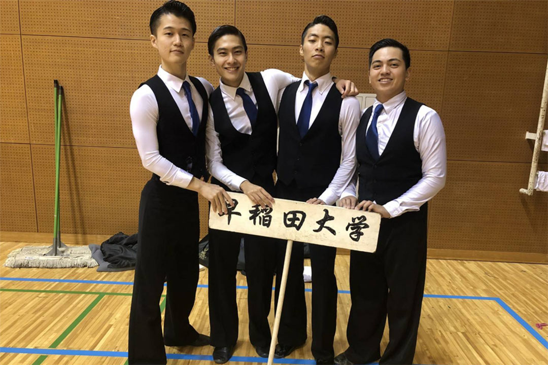 Lorenz Vargas with a group of students dressed in suits and ties